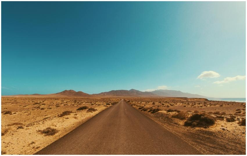 Straight road stretches into the arid desert under