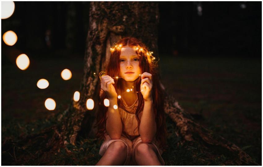 A young girl with fairy lights creates a magical e