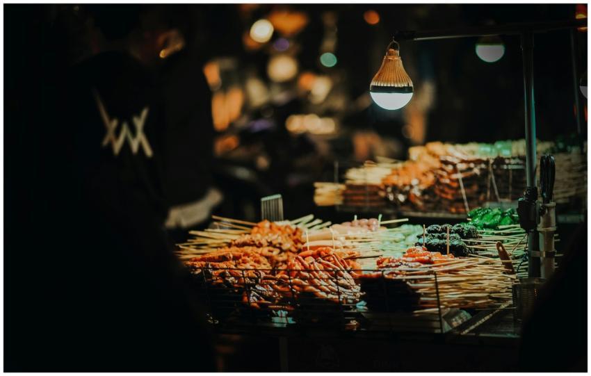 Vibrant street food skewers at a lively night mark