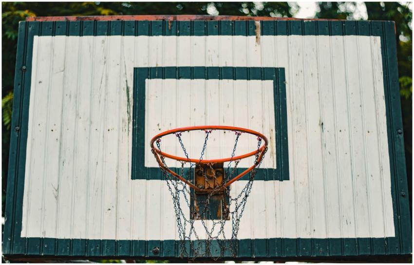 A rustic basketball hoop with a weathered backboar