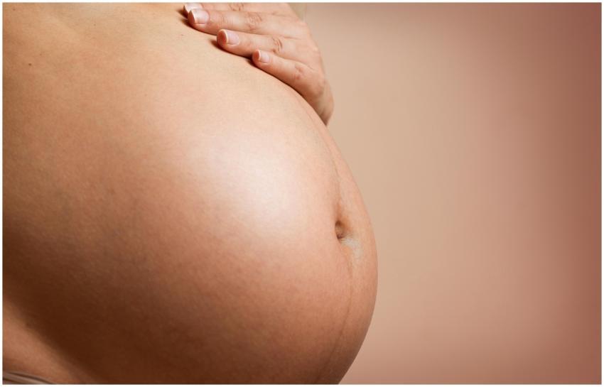 An intimate close-up of a pregnant woman's abdomen