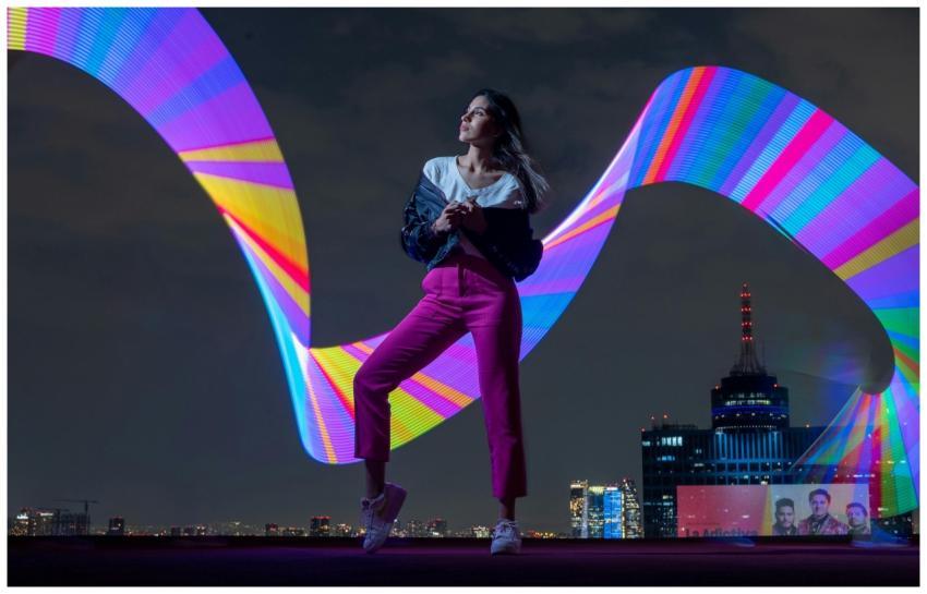 Night urban portrait of a woman posing with vibran