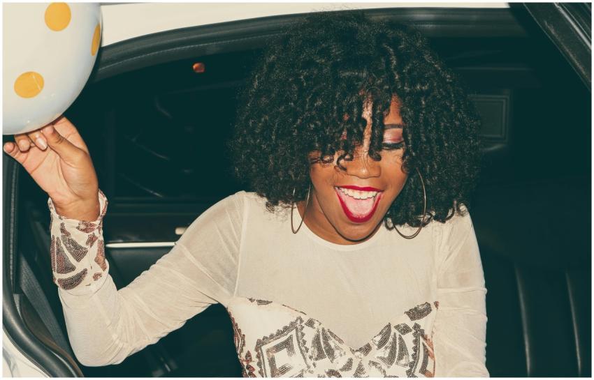 A happy young woman with curly hair enjoying a nig