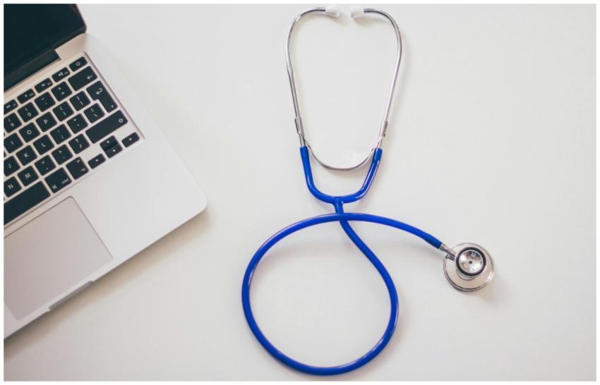 Medical stethoscope and laptop on a white desk, sy