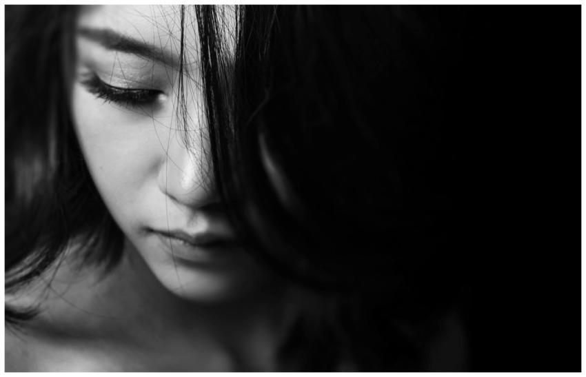 Monochrome close-up of a young woman with a though