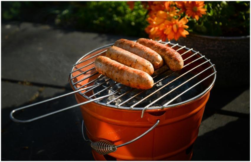 Four delicious sausages sizzling on a portable cha