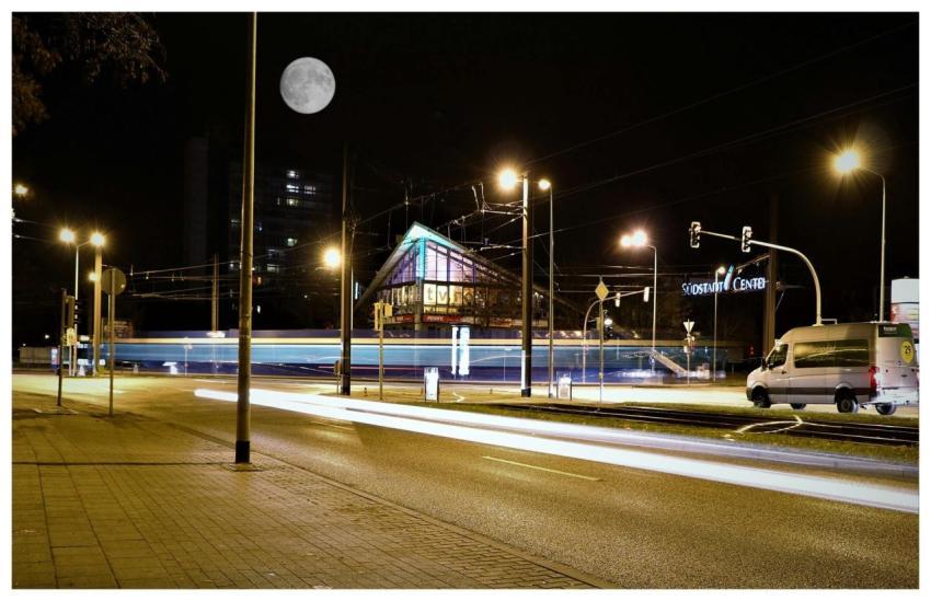 City street at night showing light trails from veh