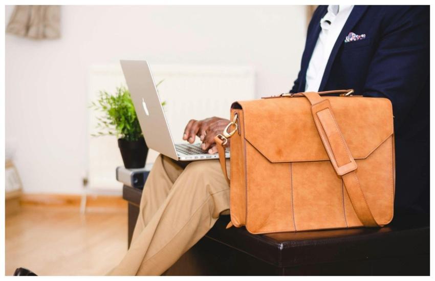 A stylish businessman working on a laptop indoor w