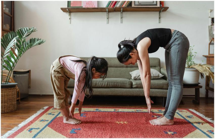 A mother and daughter practicing yoga in a cozy li