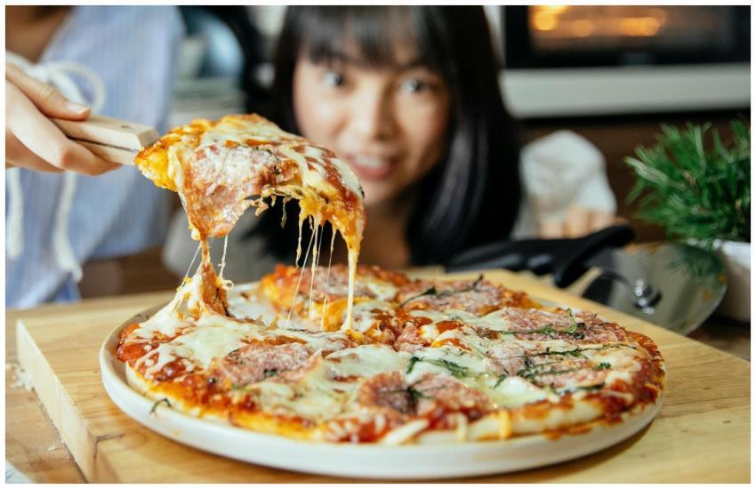 Delicious cheesy pizza with toppings being served