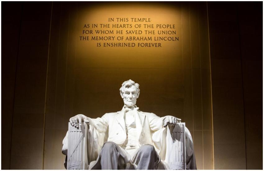 Illuminated Lincoln Memorial statue with engraved