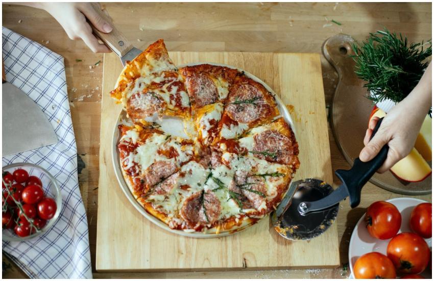 From above unrecognizable women taking slice of pi