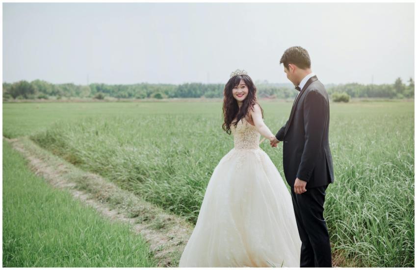 A joyful bride and groom holding hands in a green