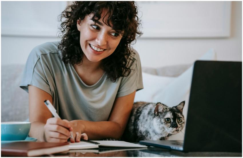 Crop young positive female smiling and taking note