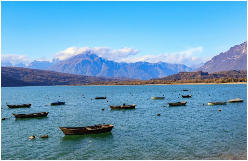 Tranquil lake scene with boats and mountains under