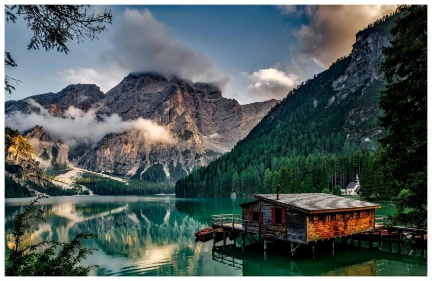Peaceful mountain lake scene featuring a rustic bo