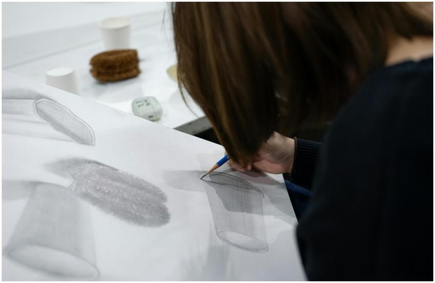 An art student focuses on sketching a still life c