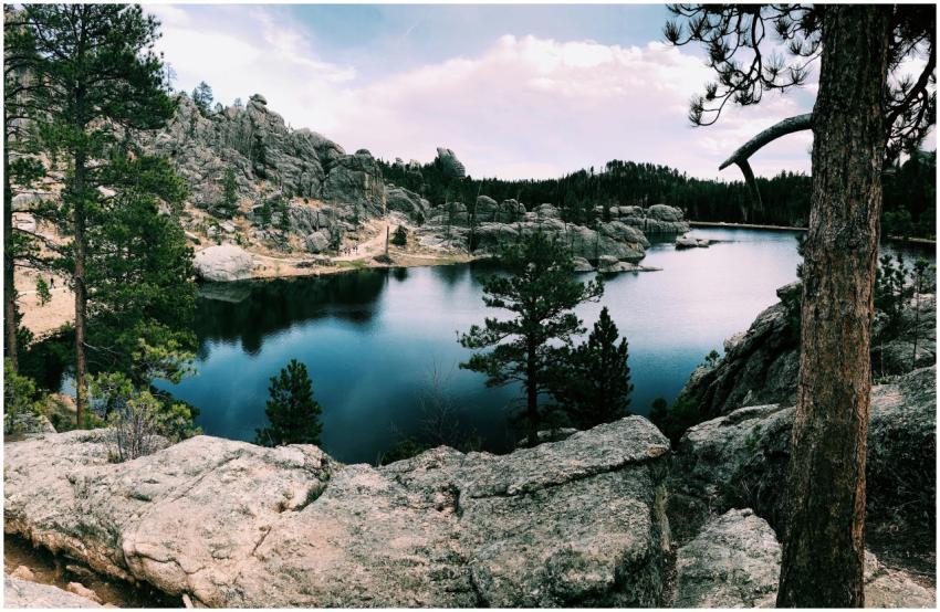 Serene lake surrounded by rocky hills and conifer