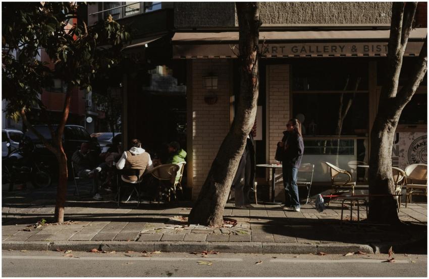 A cozy street cafe with people enjoying a sunny af