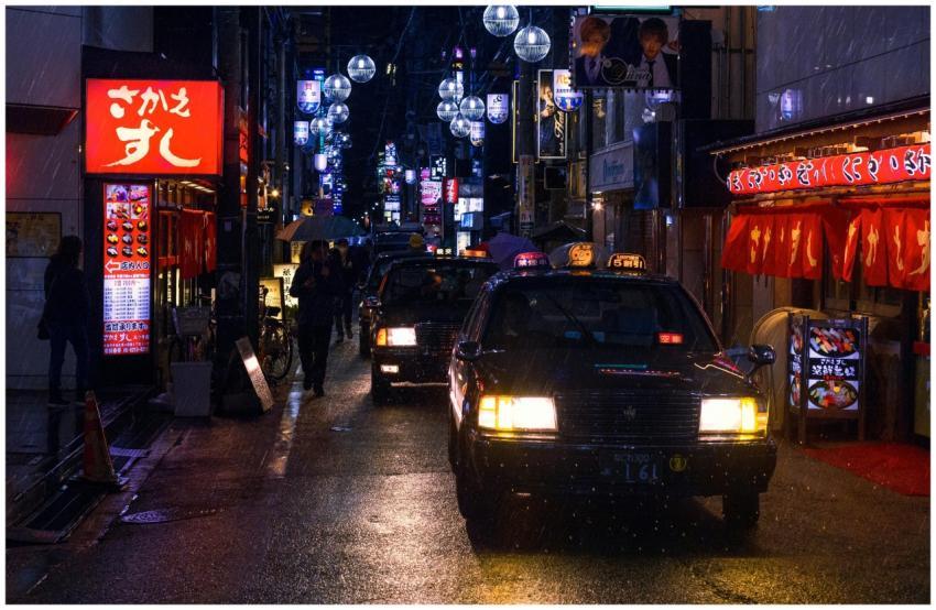 A rainy night in Tokyo with bustling streets, glow