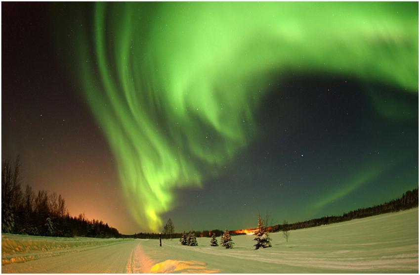 Vibrant green aurora borealis lighting up the snow