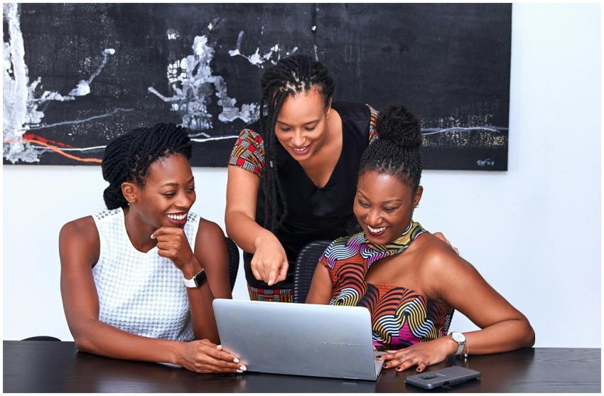 Three African American women collaborating at a la