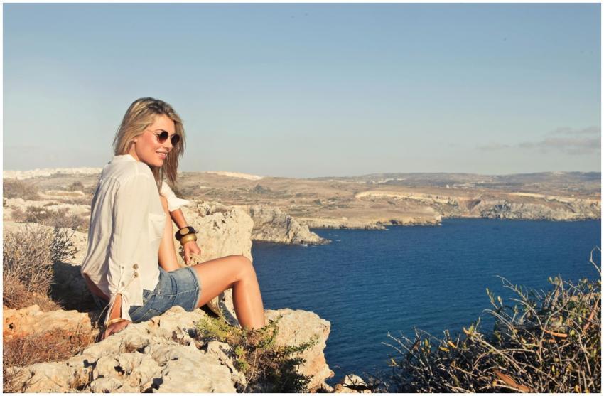 A woman enjoying a sunny day on the cliffs of Mgar