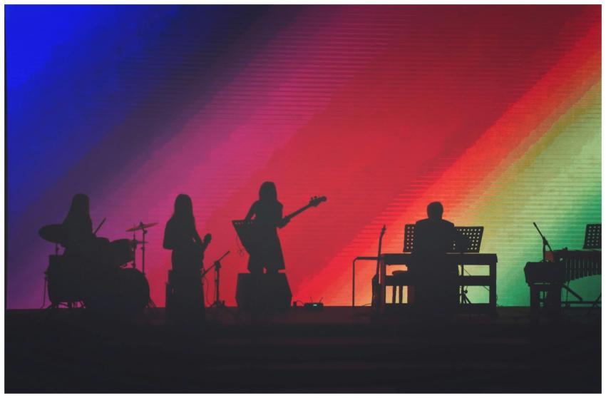 Silhouette of musicians performing on stage with v
