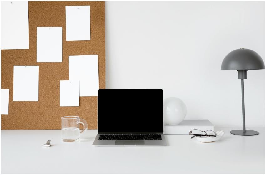 Minimalist workspace featuring a laptop, corkboard