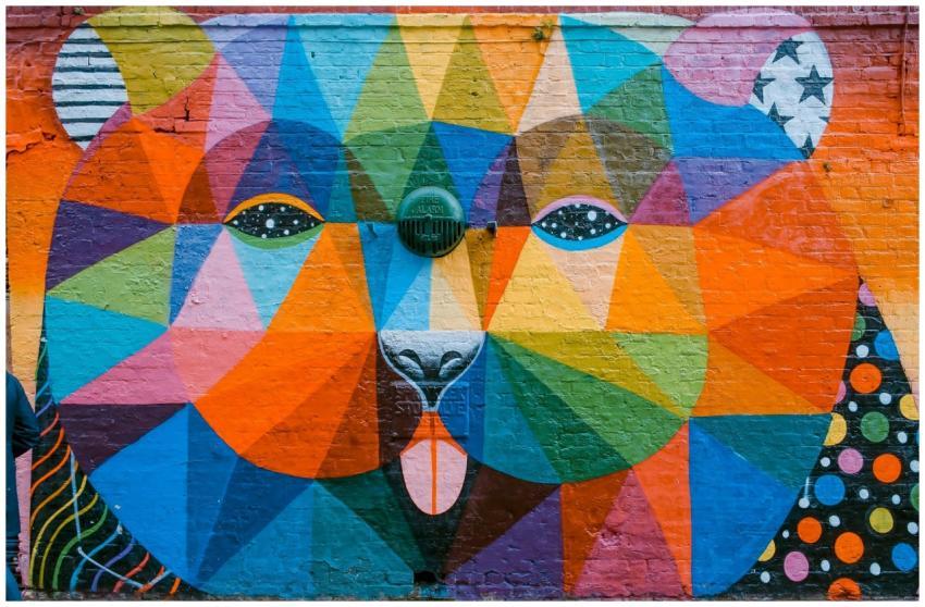 Vibrant geometric mural of a bear on a brick wall