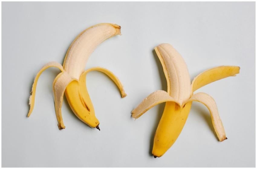 Two peeled bananas on a light background, showcasi