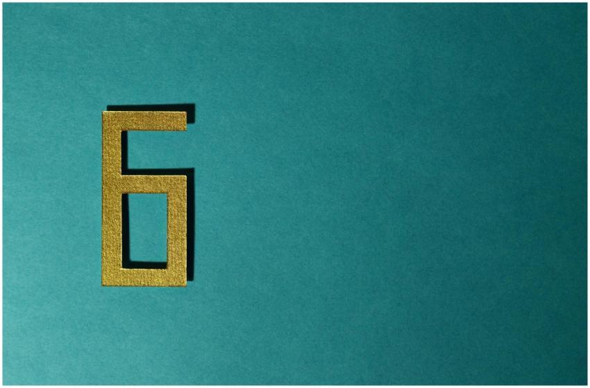 A golden number six on a teal background, perfect