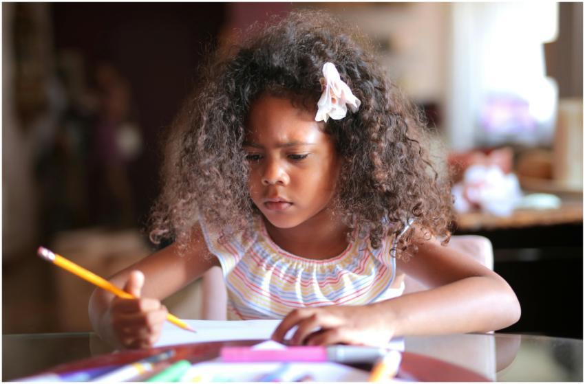 African American child focused on homework, writin