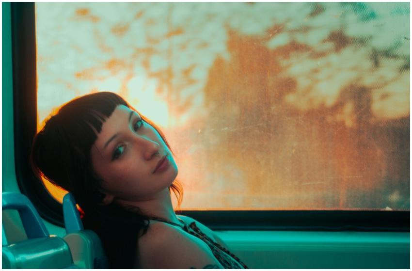 Woman with short hair on a train at sunset in Arge