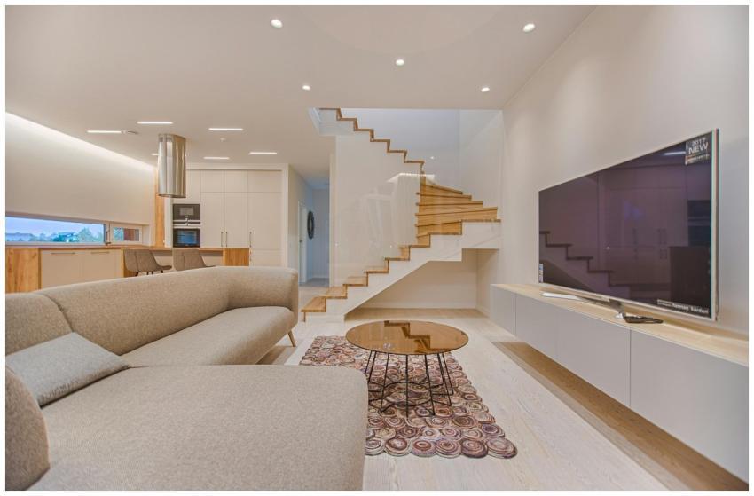 Spacious modern living room featuring stairs, a TV