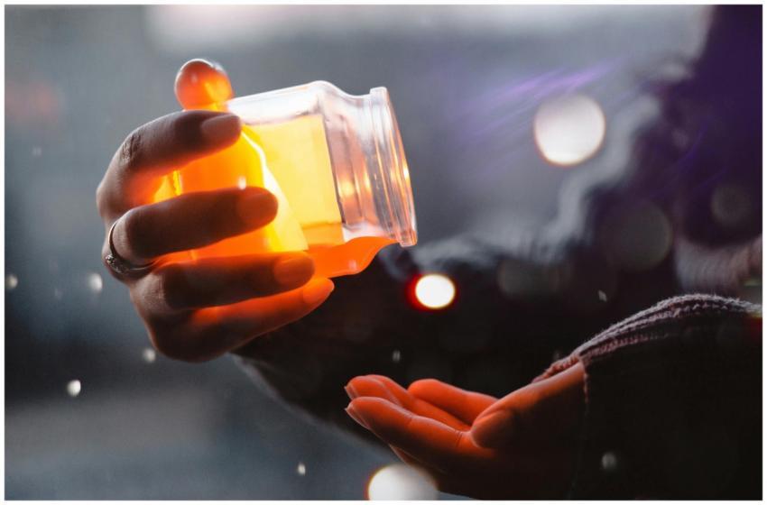 A hand holding a glowing jar, creating a warm and