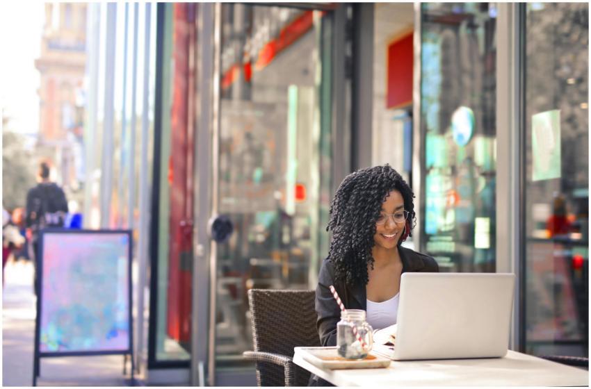 Smiling woman with curly afro hair typing on a lap