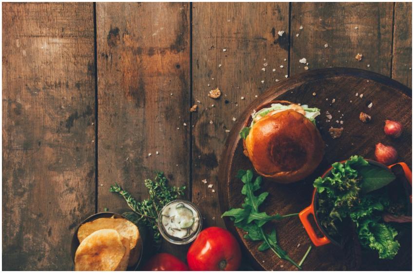 Top view of a rustic wooden table with a burger, v