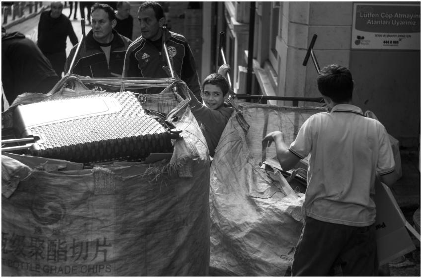 Black and white photo of a child and adults recycl