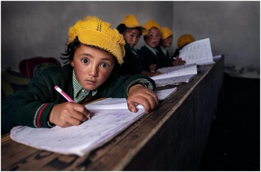 Young students attentively writing in class, weari