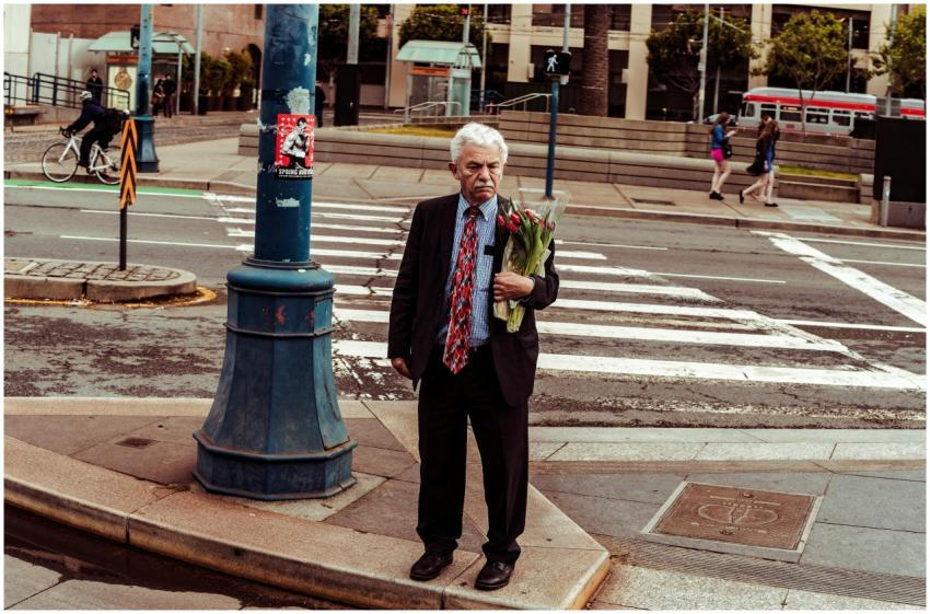Elderly man holding flowers at a San Francisco cro