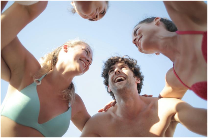 Group of happy friends laughing in swimwear under