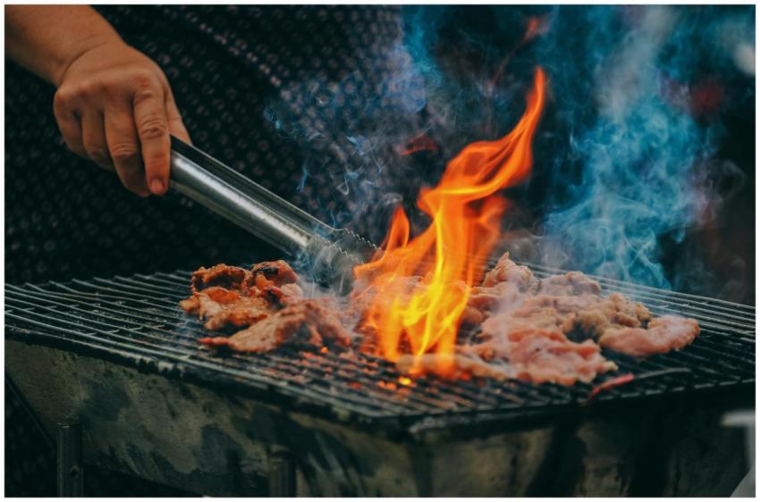 Close-up of grilling meat with vibrant flames and