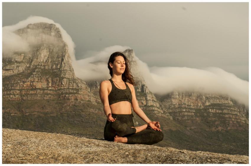 A woman practicing yoga and meditation outdoors in