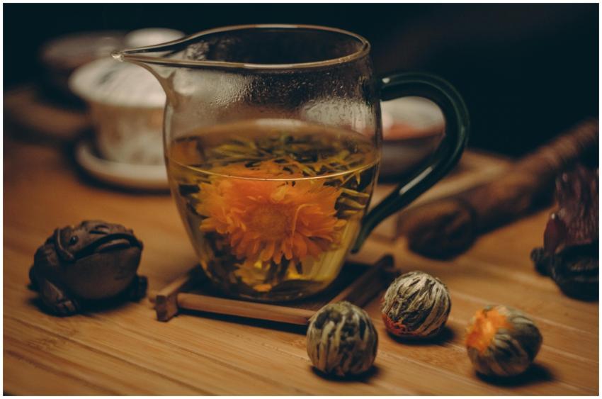 A glass cup of chrysanthemum tea with blooming flo