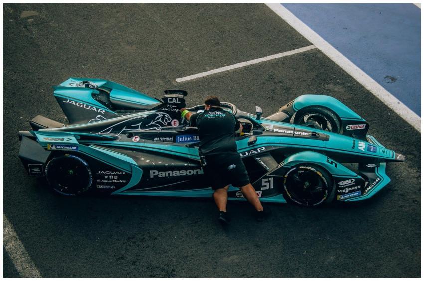 A pit crew member attends to a Formula E Jaguar ra