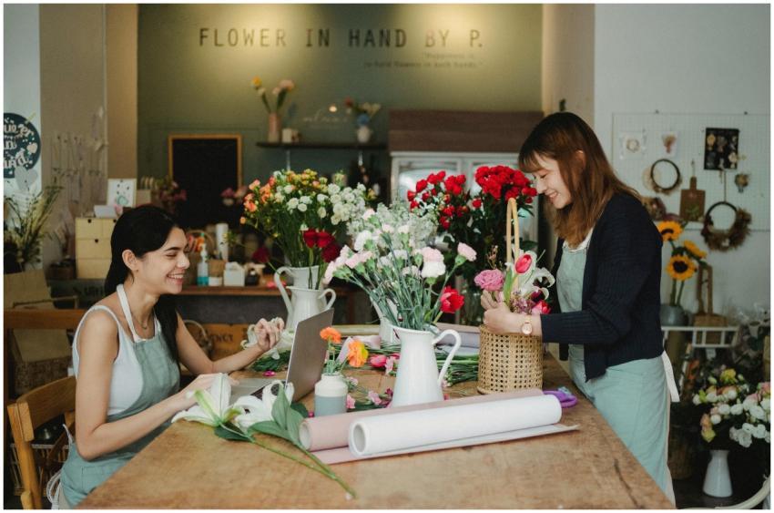 Two women florists happily arranging flowers in a