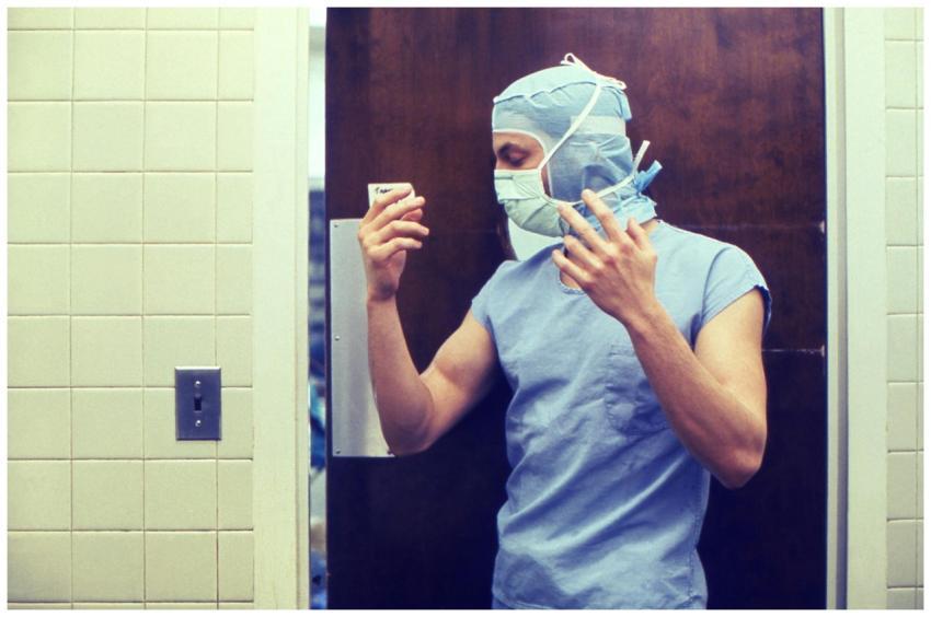 A medical practitioner in full PPE preparing in a