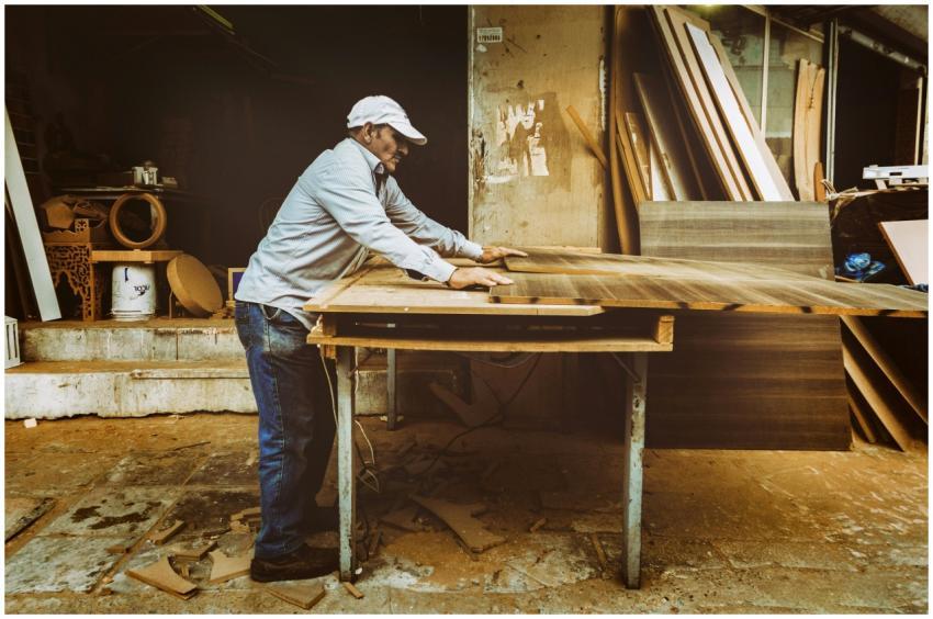 Carpenter focuses on woodworking project inside a