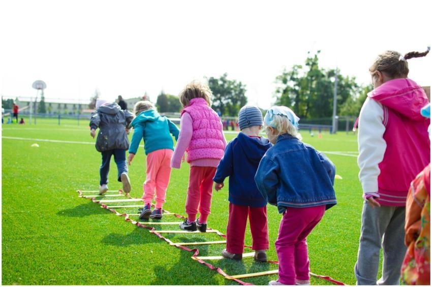 Children enjoy an outdoor activity on a grassy fie